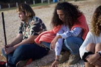 a group of people sitting on the ground looking at something